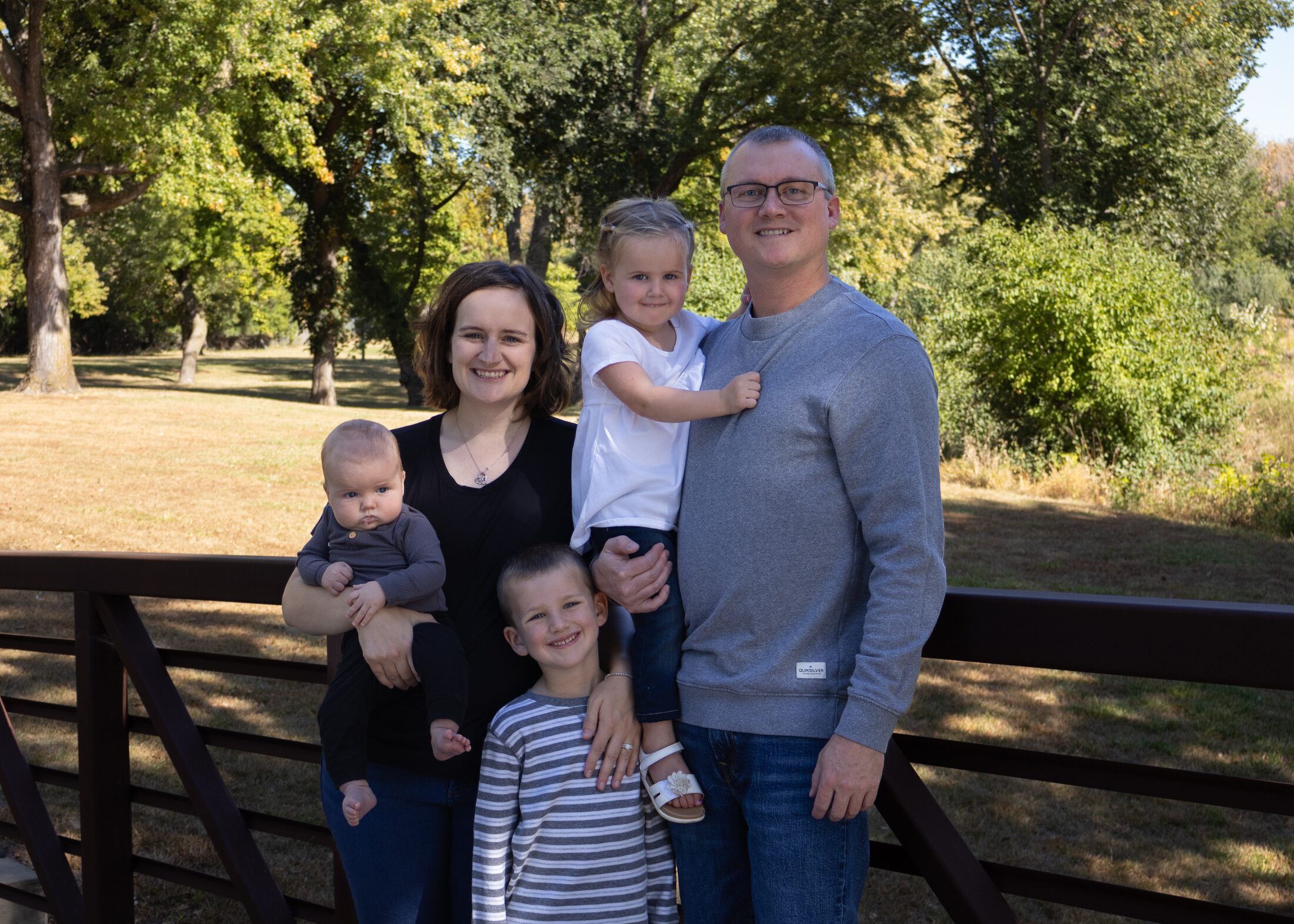 Family portrait outdoors near a wooded trail
