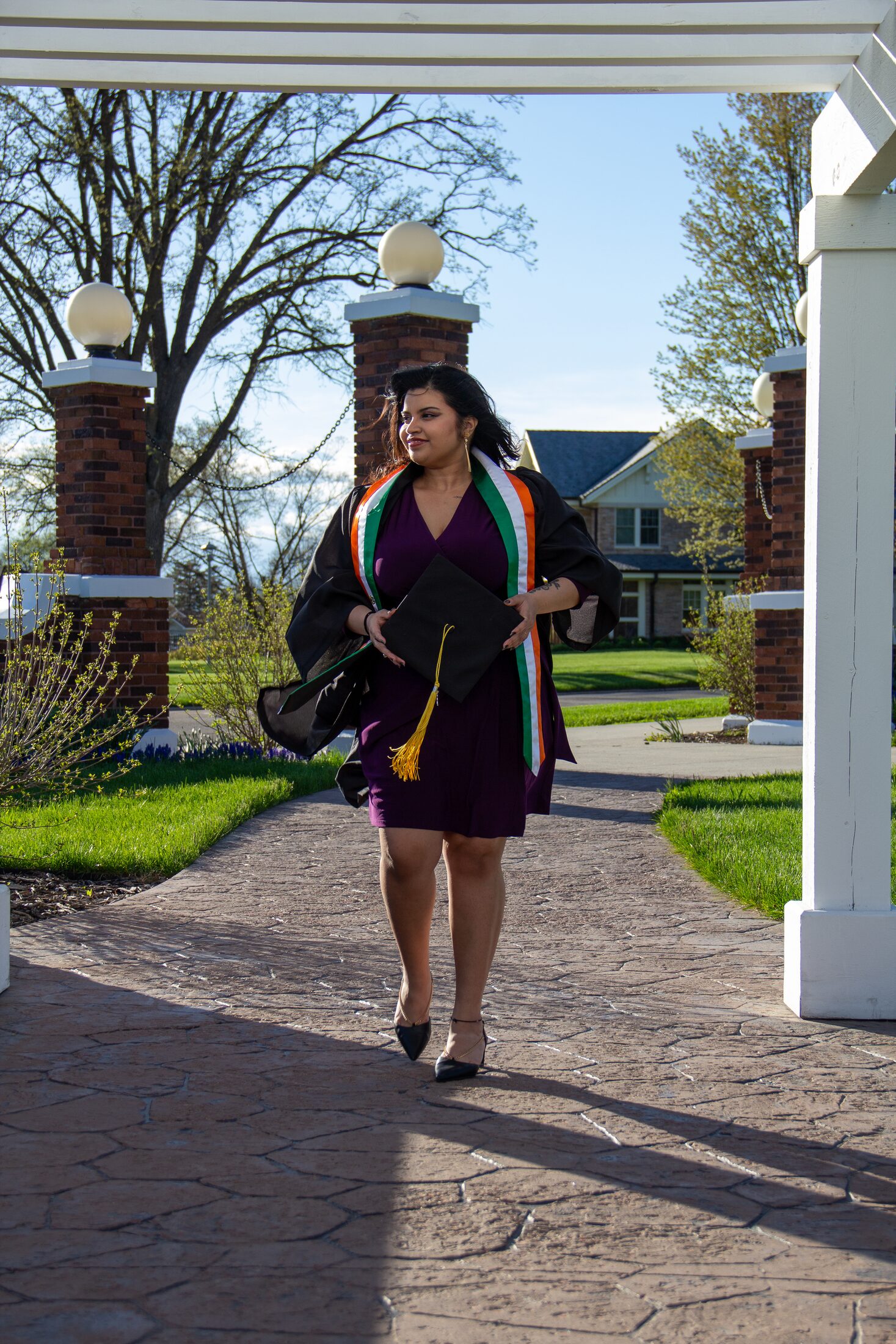 Graduate walking in cap, gown, and stole