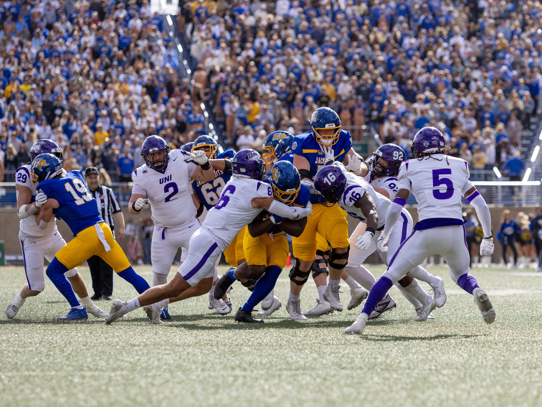 Football tackle in front of a packed crowd